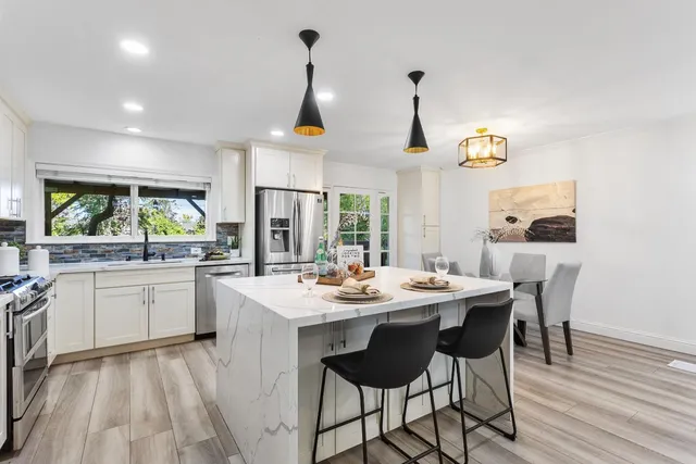 a kitchen with a sink and chairs