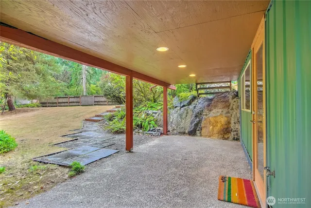 a view of an empty room with floor to ceiling windows and wooden fence