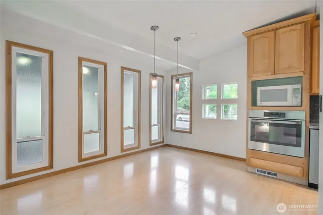 a view of an empty room with a kitchen and a window