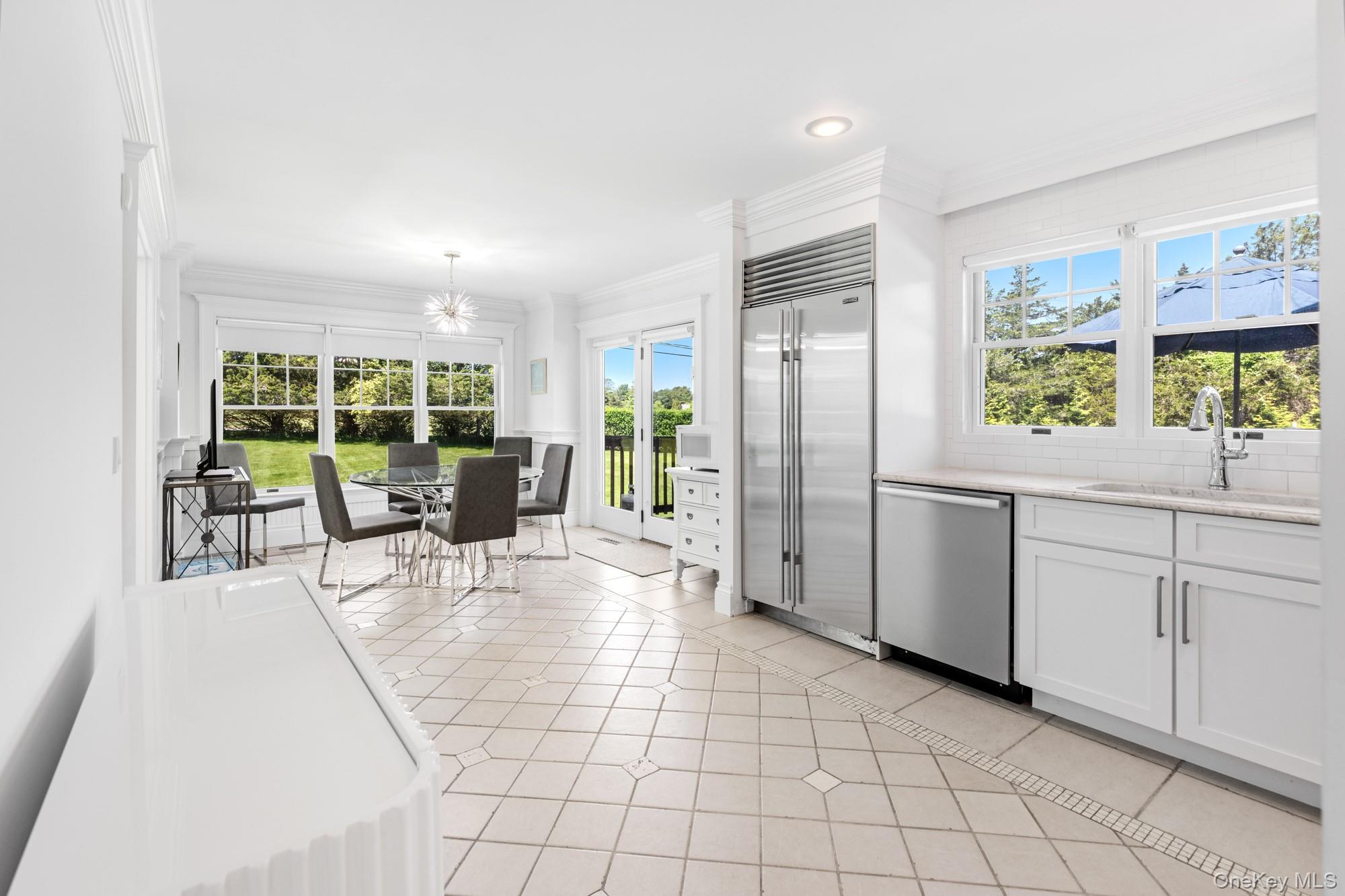 5 Lower 7 Ponds Road Water Mill, NY 11976 - Photo 11 of 35 Kitchen with stainless steel appliances, a sink, light tile patterned floors, white cabinets, and ornamental molding