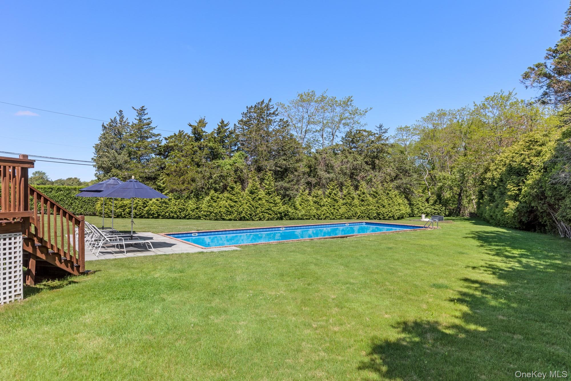5 Lower 7 Ponds Road Water Mill, NY 11976 - Photo 17 of 35 View of green lawn with stairway and an outdoor pool
