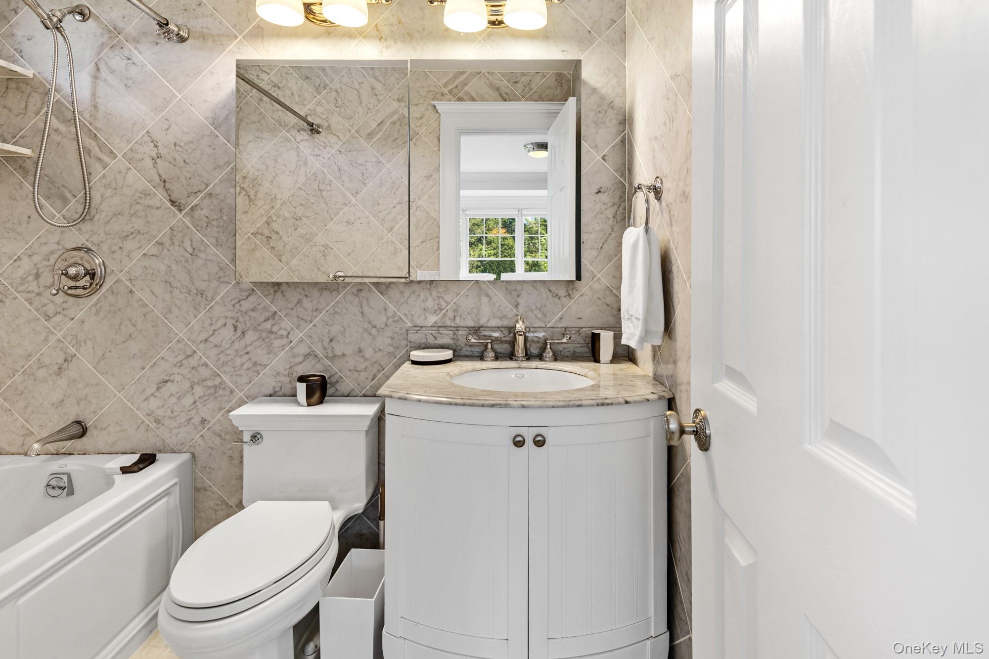 5 Lower 7 Ponds Road Water Mill, NY 11976 - Photo 20 of 35 Bathroom featuring vanity, bathtub / shower combination, toilet, and tile walls