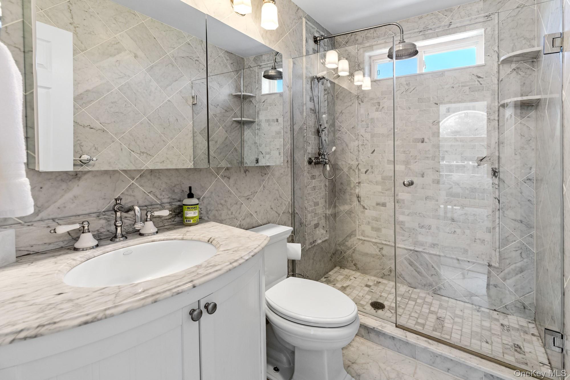 5 Lower 7 Ponds Road Water Mill, NY 11976 - Photo 23 of 35 Bathroom featuring a stall shower, vanity, toilet, and tile walls