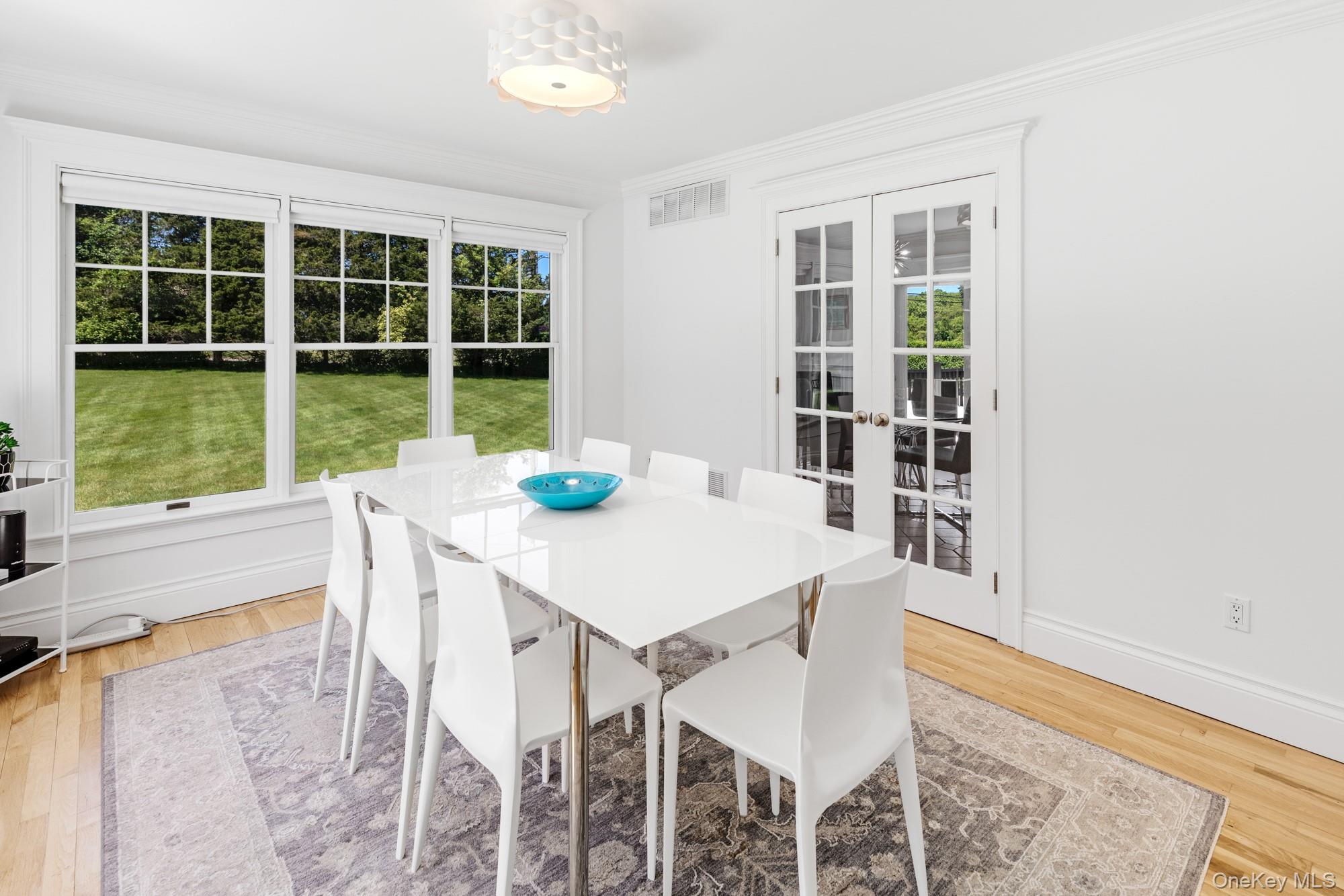 5 Lower 7 Ponds Road Water Mill, NY 11976 - Photo 6 of 35 Dining area with french doors, crown molding, light wood finished floors, and baseboards