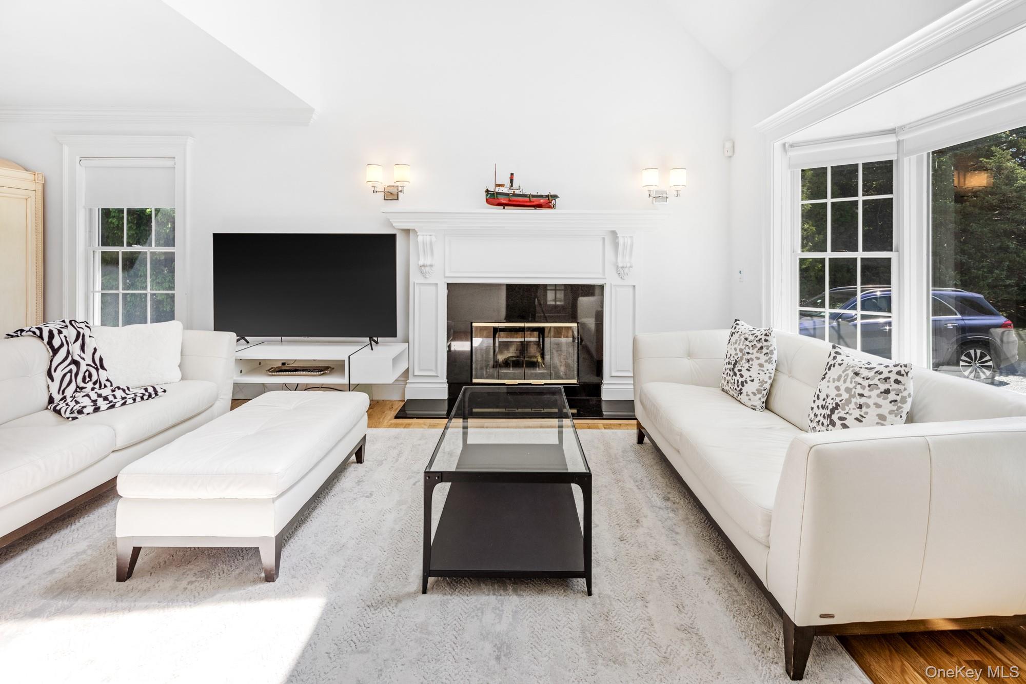 5 Lower 7 Ponds Road Water Mill, NY 11976 - Photo 10 of 35 Living area with wood finished floors, lofted ceiling, and a fireplace with flush hearth