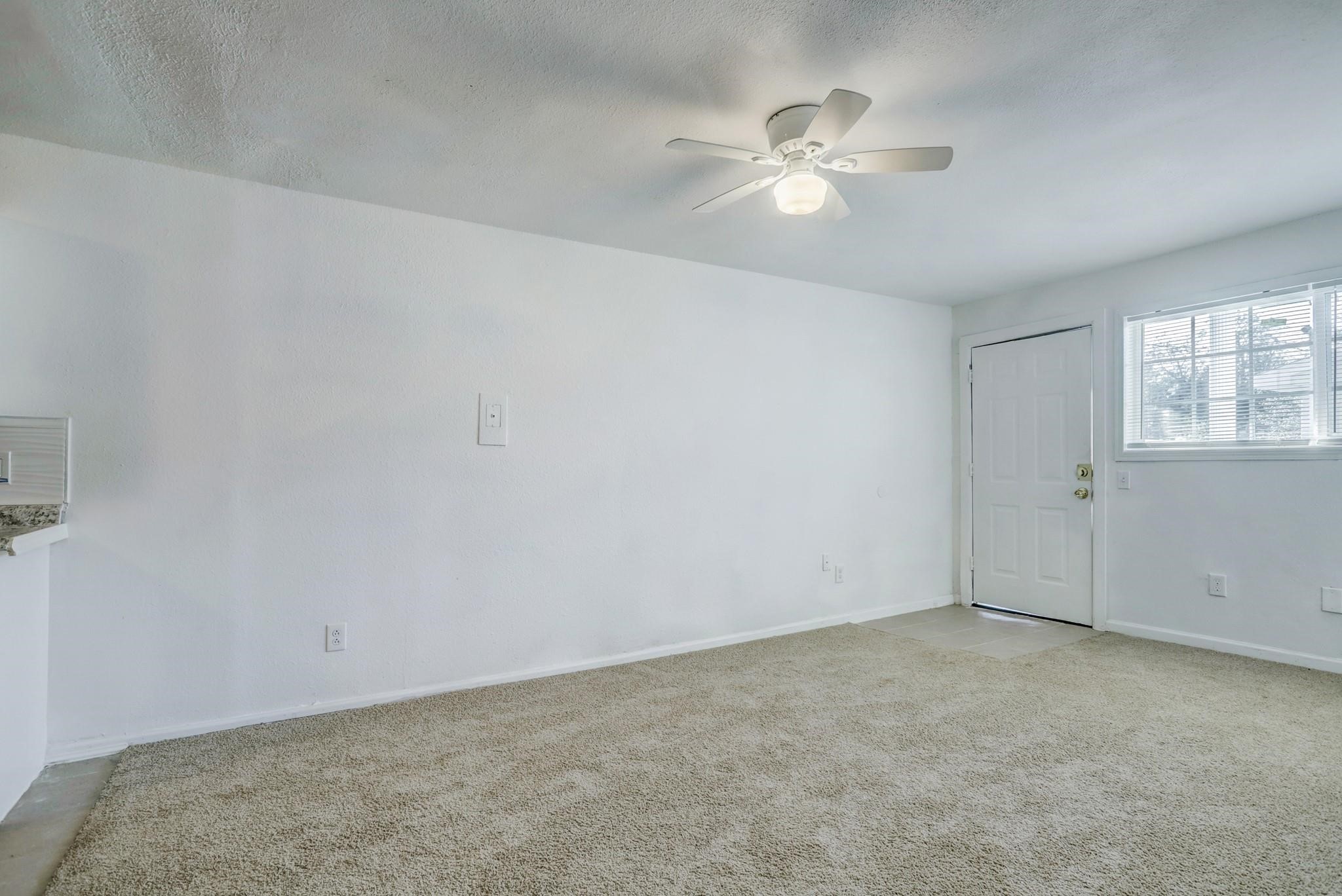 3823 Lydia Street, Unit 4 Houston, TX 77021 - Photo 6 of 16 an empty room with windows and chandelier fan