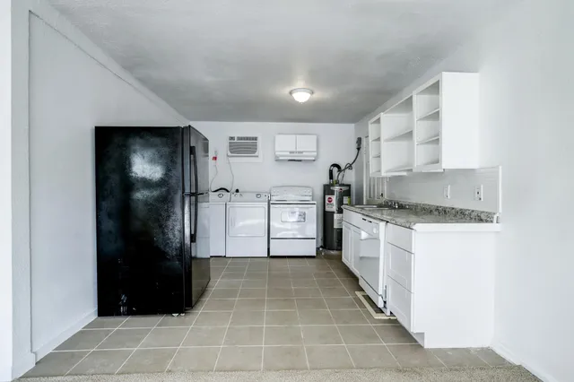 a kitchen with stainless steel appliances granite countertop a refrigerator and a stove