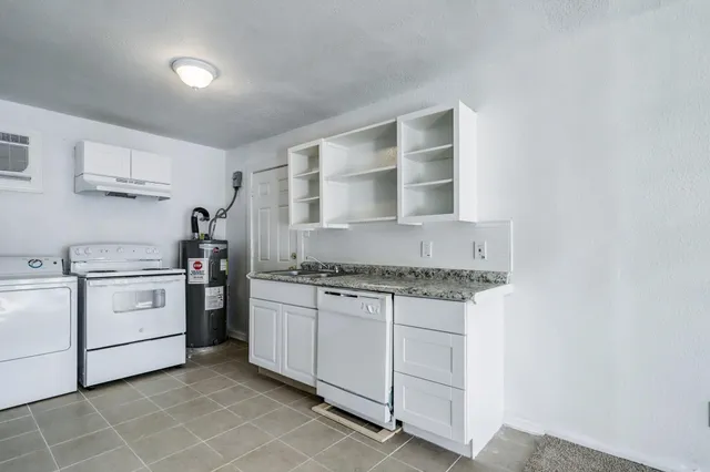 a kitchen with white cabinets and white appliances