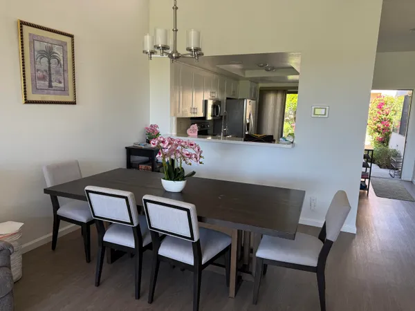 a view of a dining room with furniture a chandelier and wooden floor