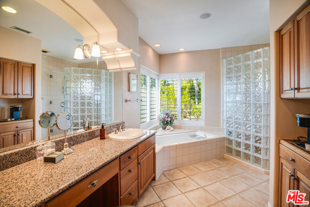 1643 La Vista Del Oceano Santa Barbara, CA 93109 - Photo 16 of 36 a spacious bathroom with a granite countertop double vanity sink a mirror and a bathtub
