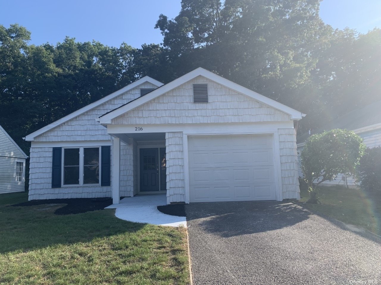 216 Belfast Lane, Unit 216 Ridge, NY 11961 - Photo 1 of 1 a front view of a house with garden