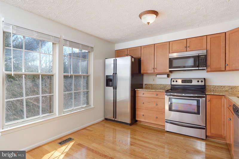 1949 Belmont Ridge Court Reston, VA 20191 - Photo 6 of 23 a kitchen with granite countertop a refrigerator and a stove top oven