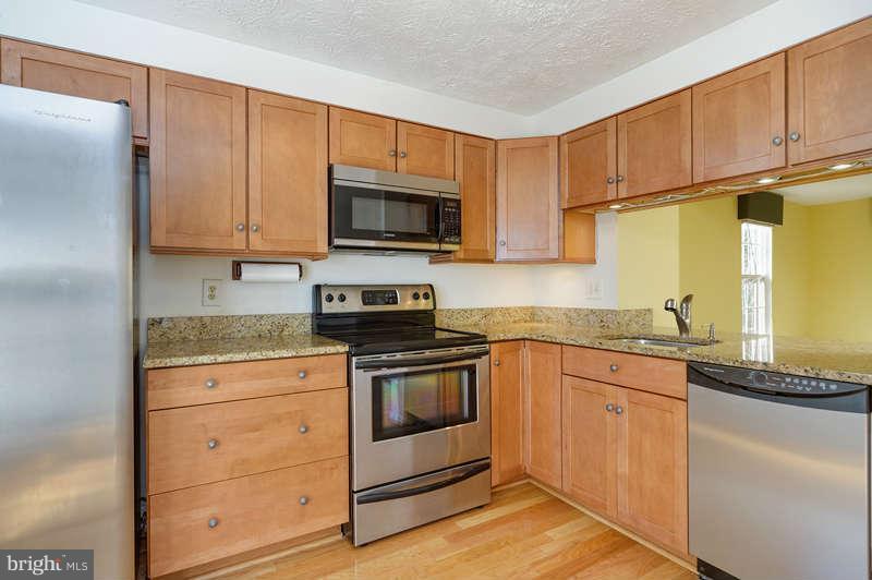 1949 Belmont Ridge Court Reston, VA 20191 - Photo 7 of 23 a kitchen with granite countertop wooden cabinets stainless steel appliances and a counter space
