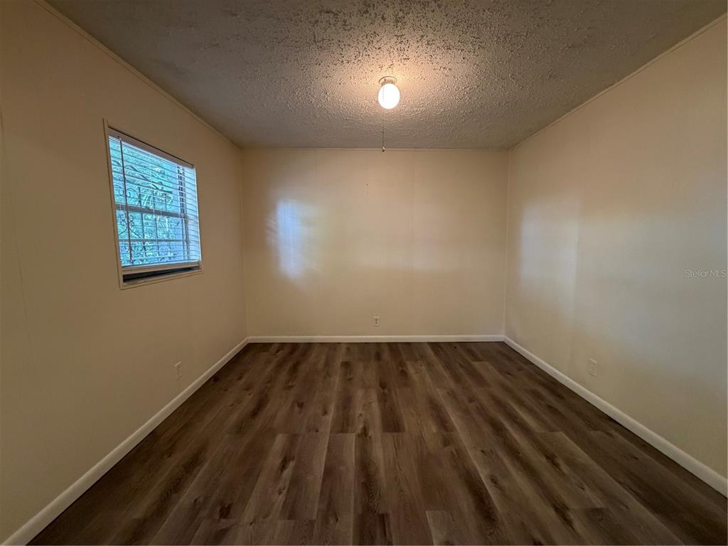 1740 West Walnut Street Tampa, FL 33607 - Photo 23 of 28 an empty room with wooden floor and windows