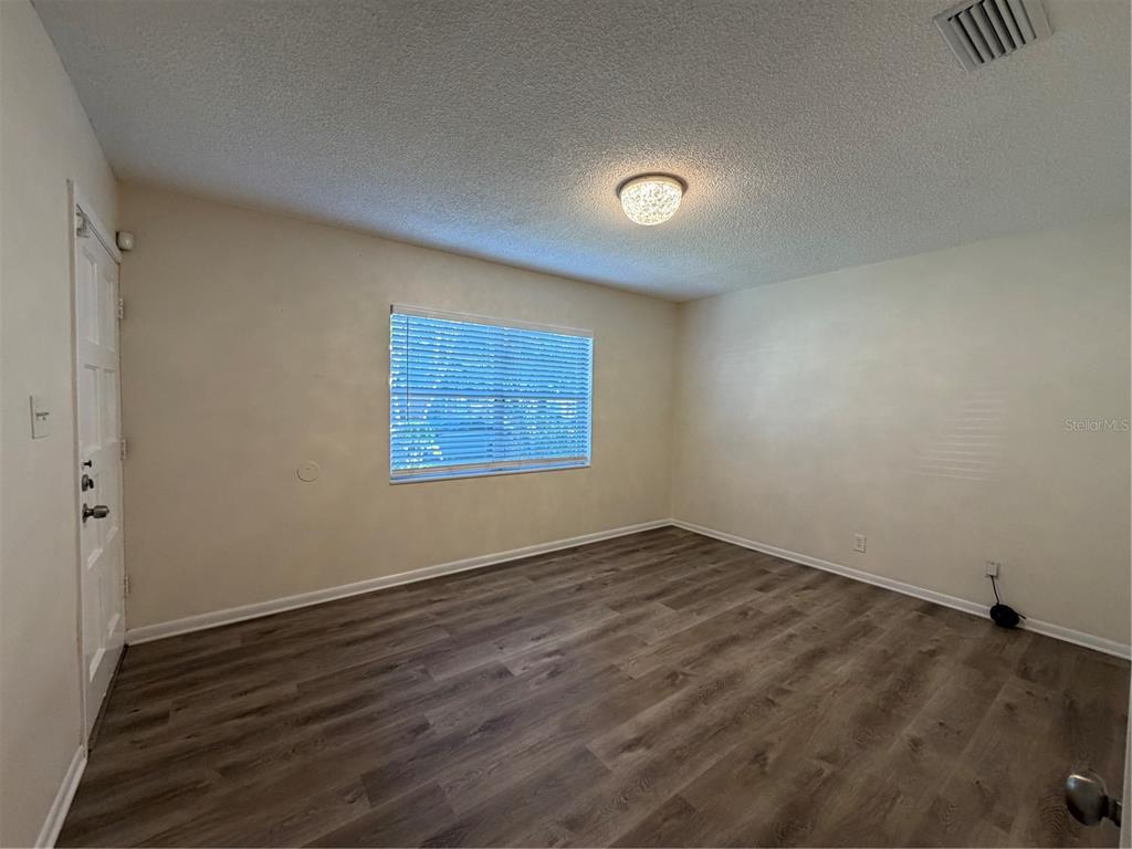 1740 West Walnut Street Tampa, FL 33607 - Photo 3 of 28 an empty room with wooden floor and windows