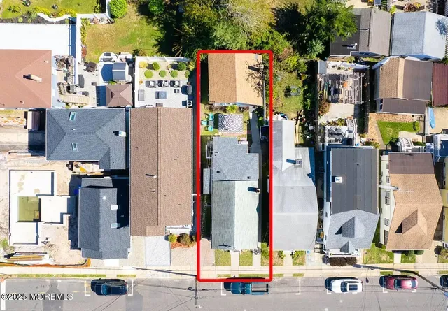 an aerial view of residential houses with outdoor space and parking