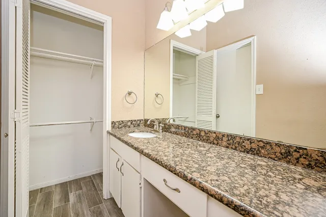 a bathroom with a granite countertop sink and a mirror