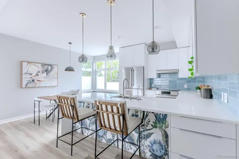 a kitchen with stainless steel appliances granite countertop a kitchen island a stove a table and chairs