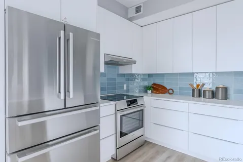 a kitchen with a sink stove and white cabinets