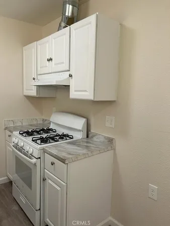 a white stove top oven sitting inside of a kitchen