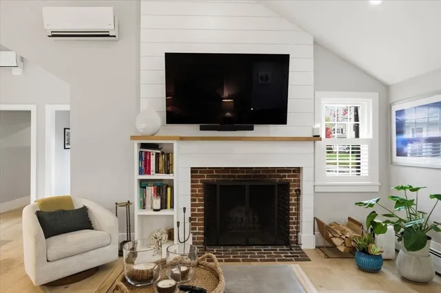 a living room with furniture a flat screen tv and a fireplace