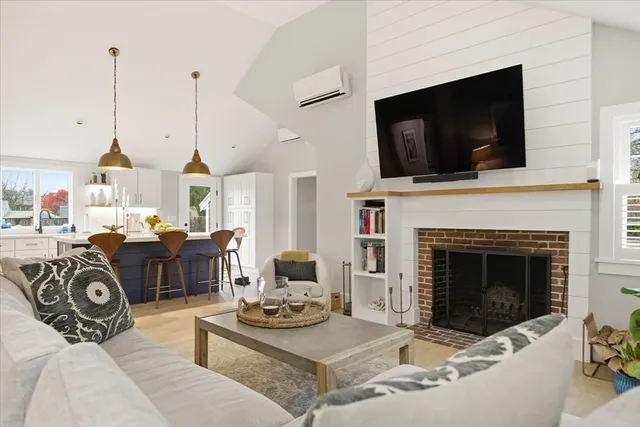 a living room with furniture a flat screen tv and a fireplace