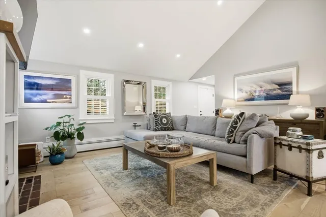 a living room with furniture potted plant and paintings on the wall