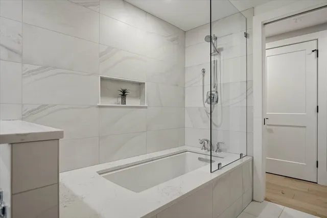 a bathroom with a tub a toilet and a shower