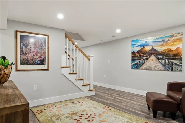 a view of a hallway with wooden floor and paintings on the wall