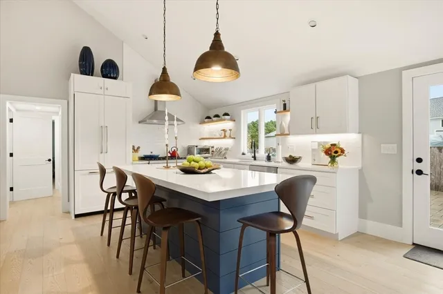 a kitchen with stainless steel appliances a dining table chairs and a chandelier