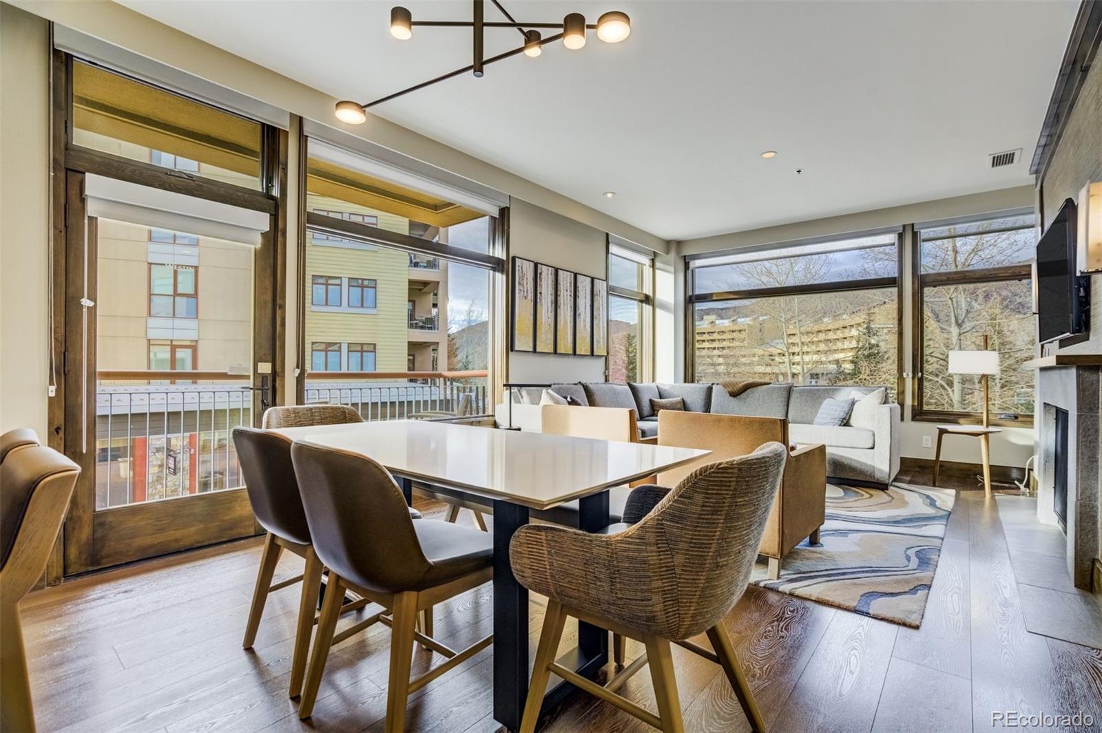 126 Riverfront Lane, Unit 200 Avon, CO 81620 - Photo 12 of 49 a view of a dining room with furniture large windows and wooden floor