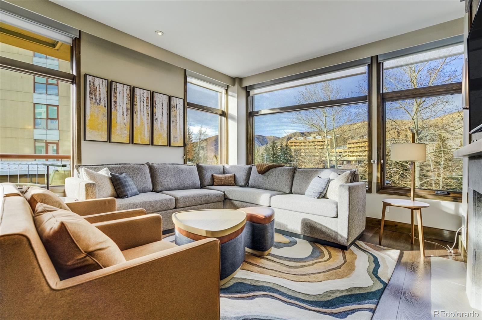 126 Riverfront Lane, Unit 200 Avon, CO 81620 - Photo 13 of 49 a living room with furniture and a floor to ceiling window