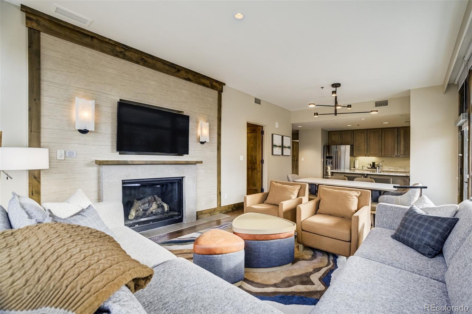 126 Riverfront Lane, Unit 200 Avon, CO 81620 - Photo 15 of 49 a living room with furniture a flat screen tv and a fireplace