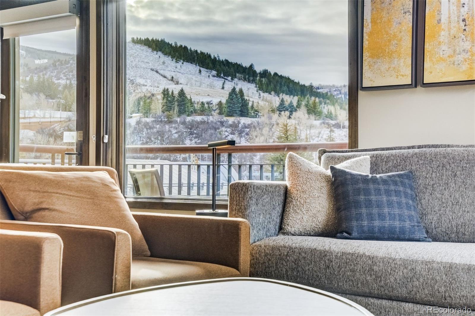 126 Riverfront Lane, Unit 200 Avon, CO 81620 - Photo 16 of 49 a living room with furniture and a large window