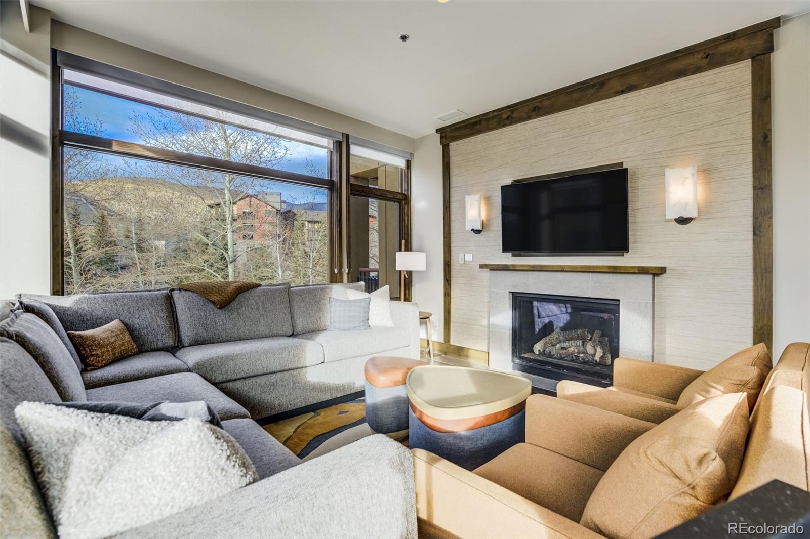 126 Riverfront Lane, Unit 200 Avon, CO 81620 - Photo 19 of 49 a living room with furniture a fireplace and a flat screen tv