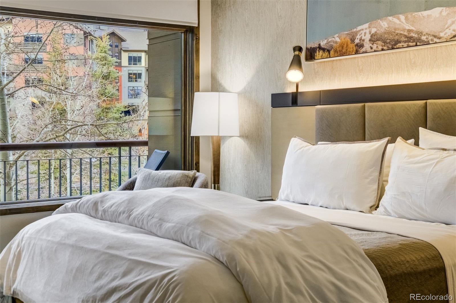 126 Riverfront Lane, Unit 200 Avon, CO 81620 - Photo 21 of 49 a bed sitting in a bedroom next to a window