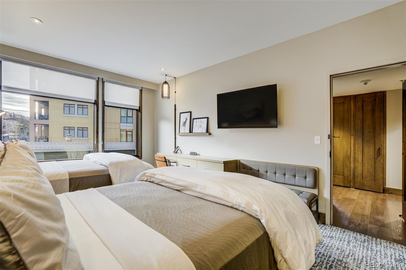 126 Riverfront Lane, Unit 200 Avon, CO 81620 - Photo 30 of 49 a bedroom with two beds and a flat screen tv