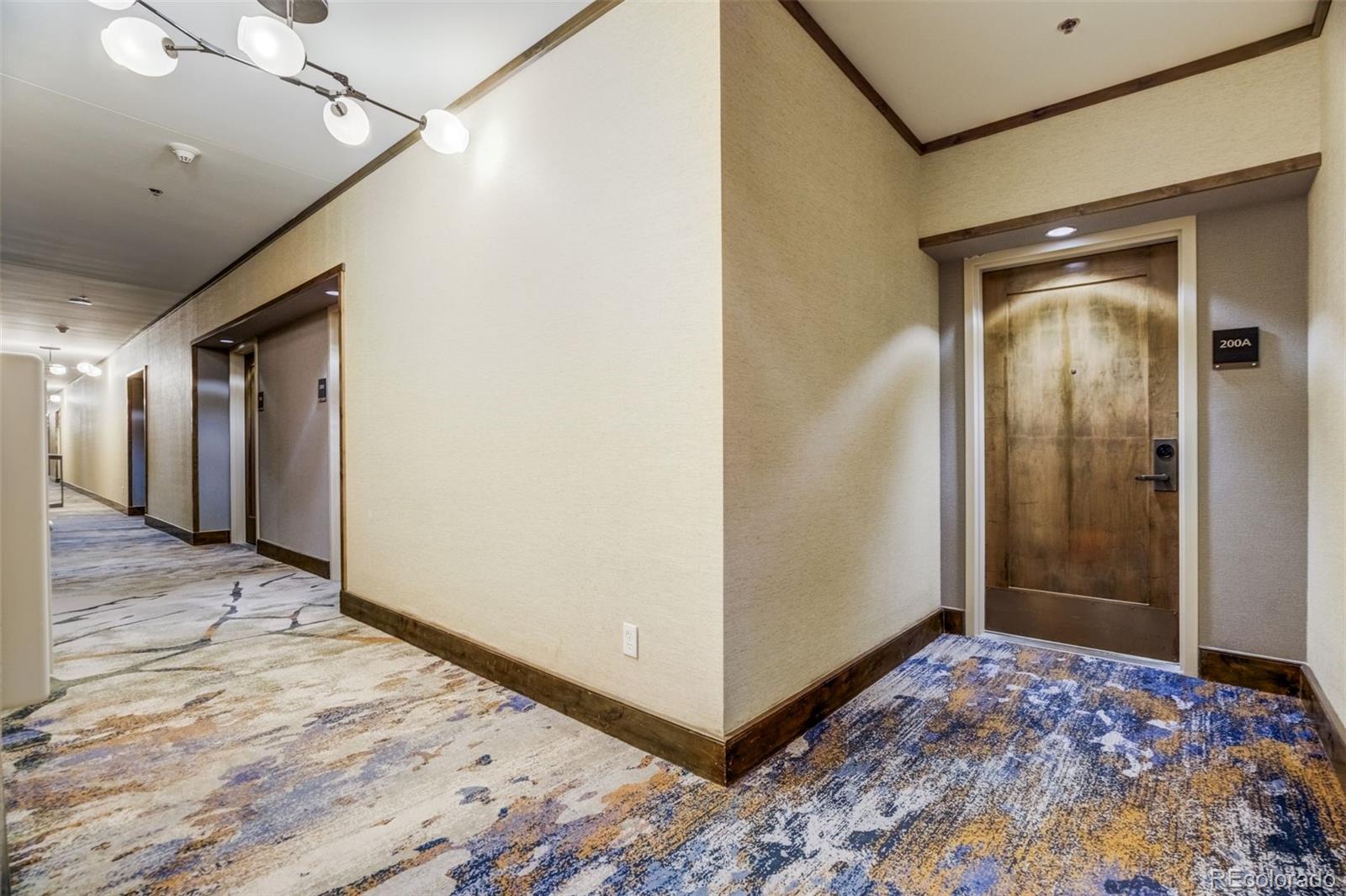 126 Riverfront Lane, Unit 200 Avon, CO 81620 - Photo 7 of 49 a view of a hallway with wooden floor