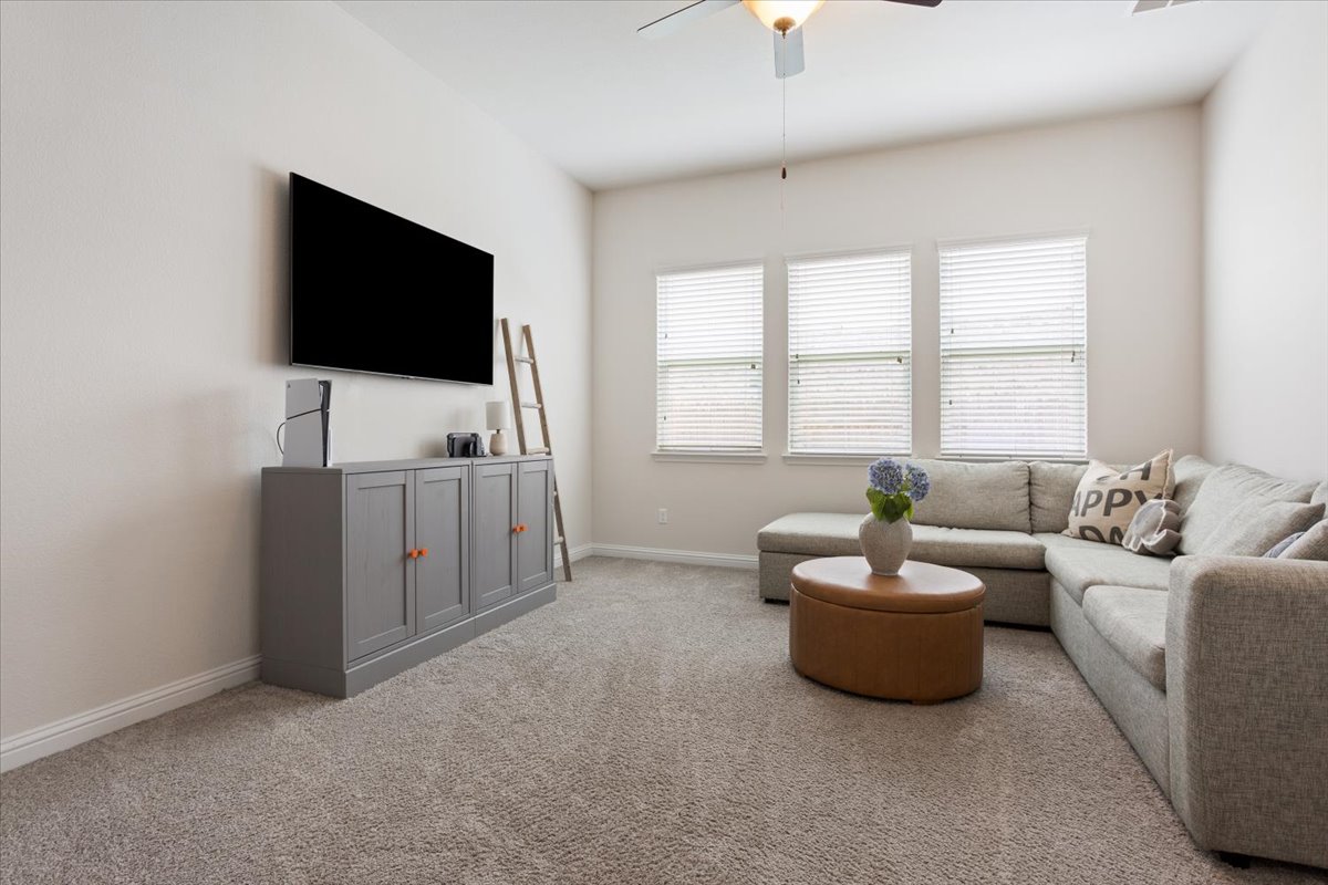 424 Millard Street Georgetown, TX 78628 - Photo 27 of 37 A comfortable living space featuring soft carpeting and natural light filtering through multiple windows.