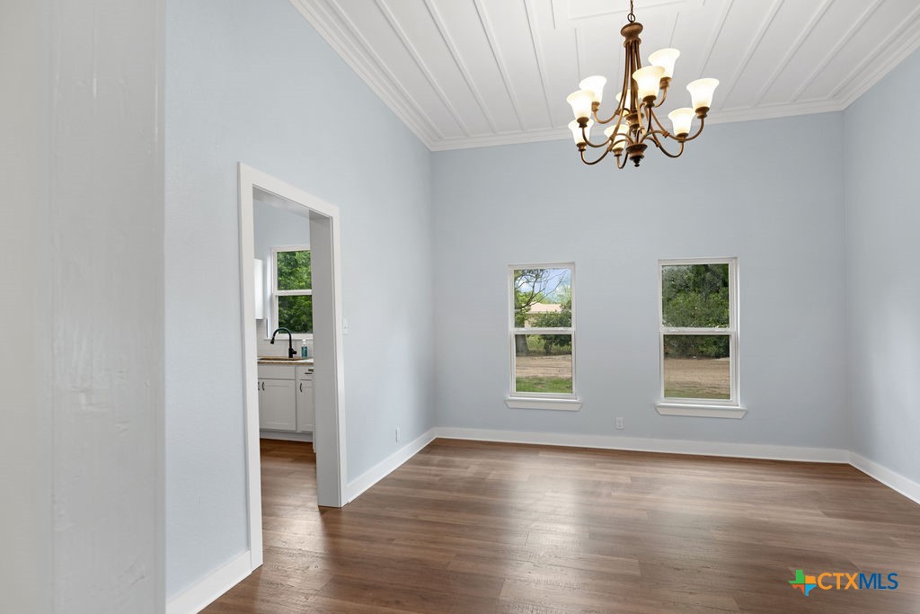 607 West 3rd Street Eddy, TX 76524 - Photo 4 of 29 a view of a room with wooden floor chandelier and windows