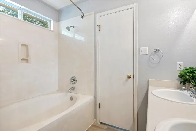 a bathroom with a tub shower sink and toilet