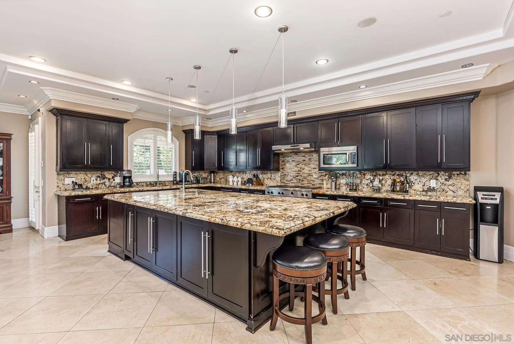 2871 Gate 3 Place Chula Vista, CA 91914 - Photo 46 of 73 a kitchen with stainless steel appliances granite countertop table chairs sink and cabinets