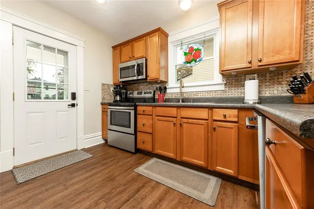 a kitchen with stainless steel appliances granite countertop a stove a sink and a microwave