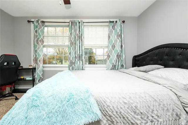 a bedroom with a bed and a large window