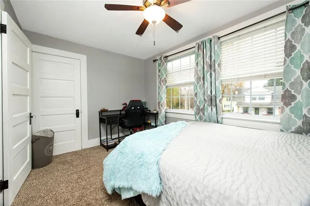 a spacious bedroom with a bed and a chandelier