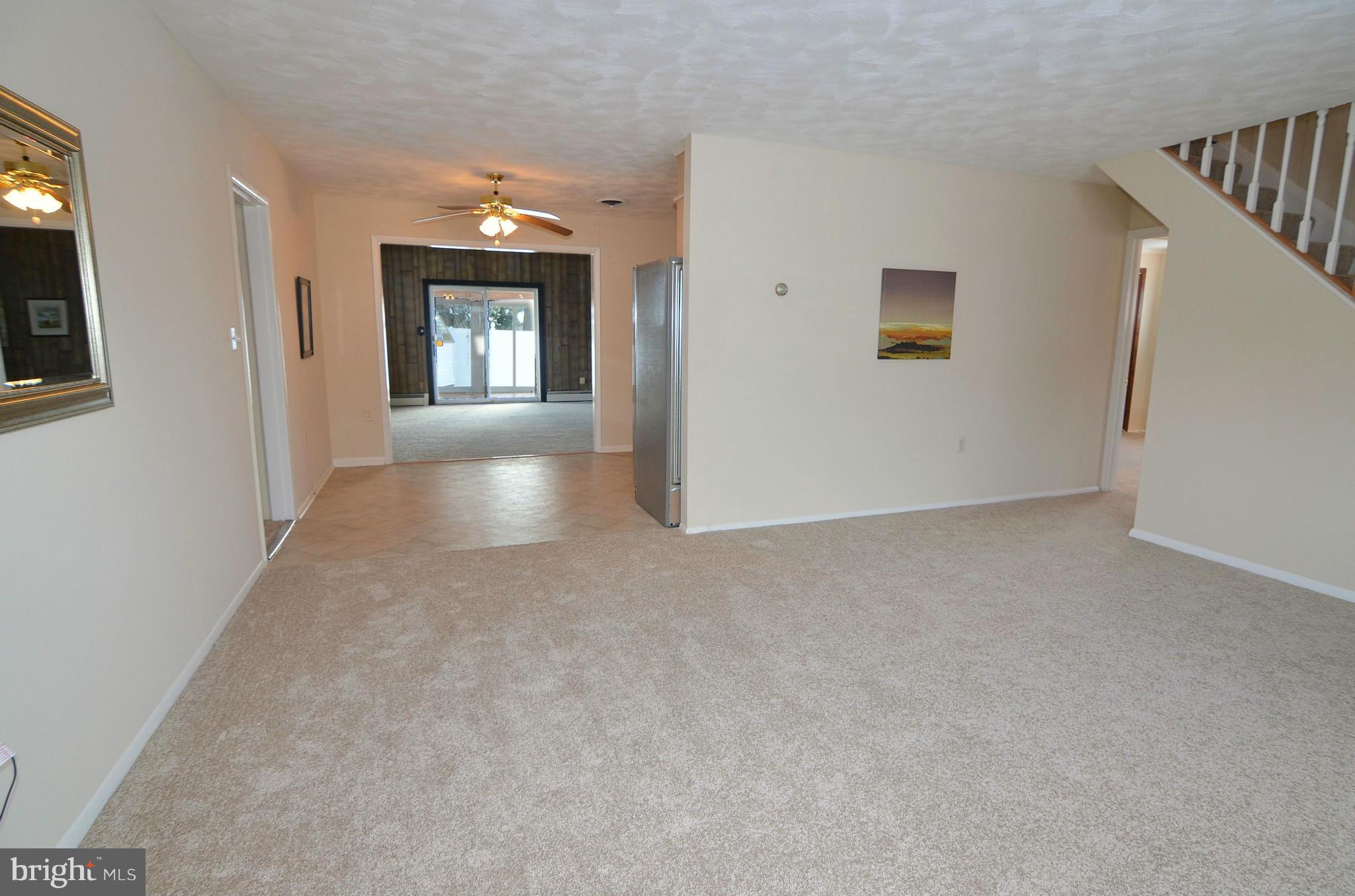 112 Thomas Road Glen Burnie, MD 21060 - Photo 6 of 30 a view of a hallway to an empty room with wooden floor and a window