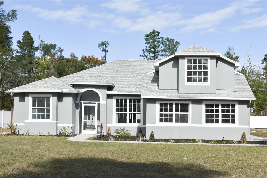 8424 Balm Street Weeki Wachee, FL 34607 - Photo 1 of 1 a front view of a house with a yard