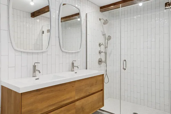 a bathroom with a sink mirror and shower