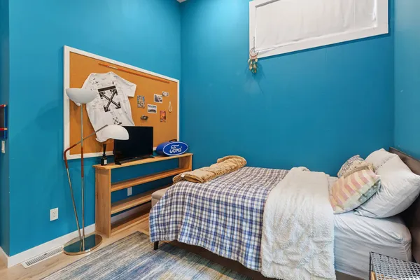 a bedroom with a bed and wooden floor