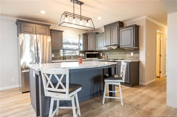 a kitchen with a stove a refrigerator and a dining table